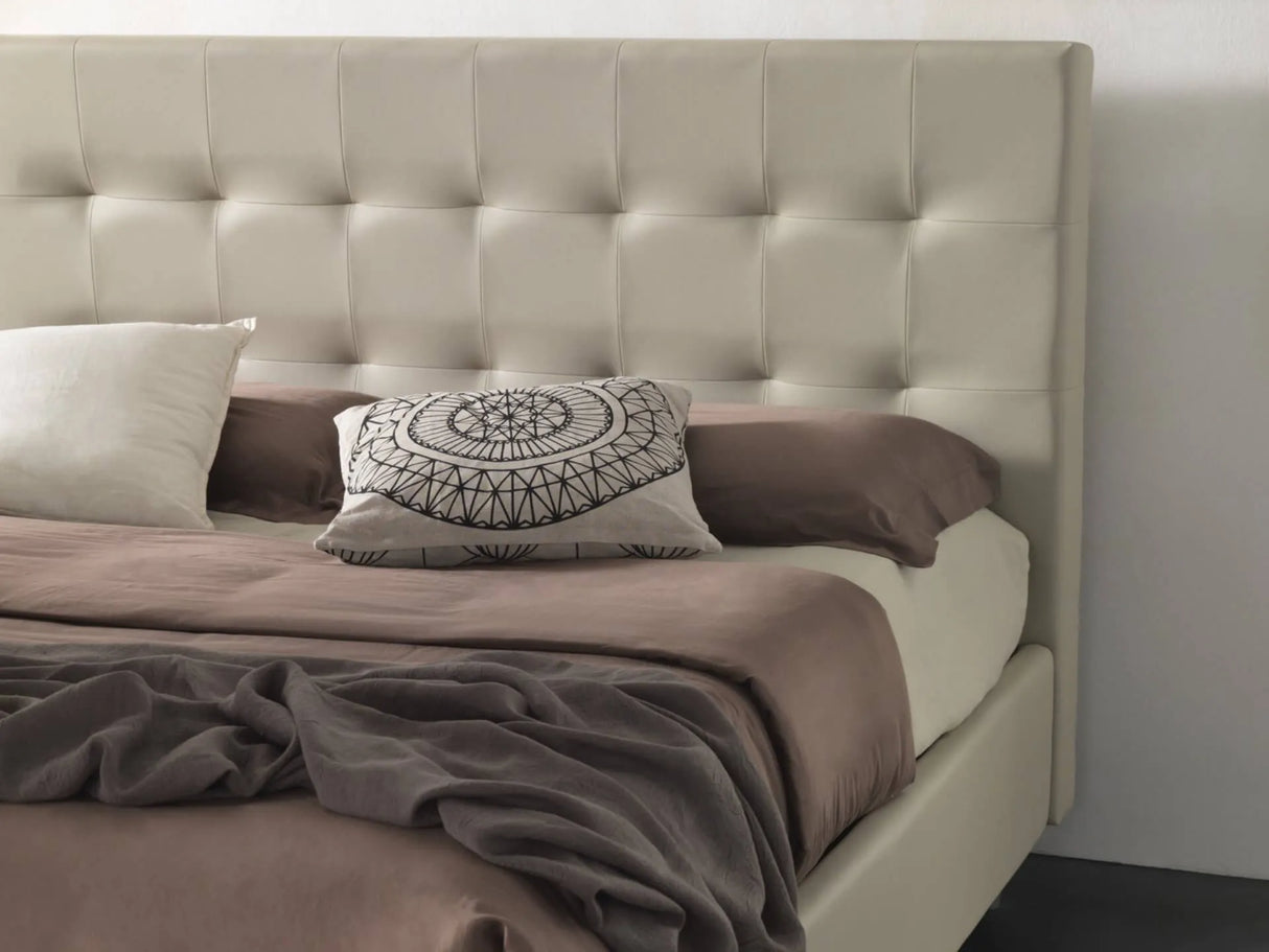 Letto matrimoniale New York con contenitore in tessuto idrorepellente, testata con impunture e piedini alti. Elegante, moderno e salvaspazio.