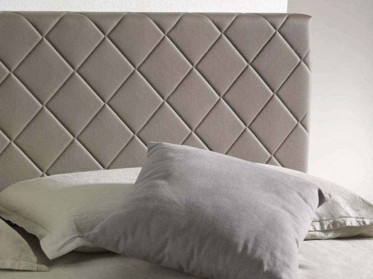 Letto matrimoniale Rio con contenitore, rivestimento in ecopelle e testata imbottita trapuntata a rombi. Design moderno, elegante e salvaspazio.