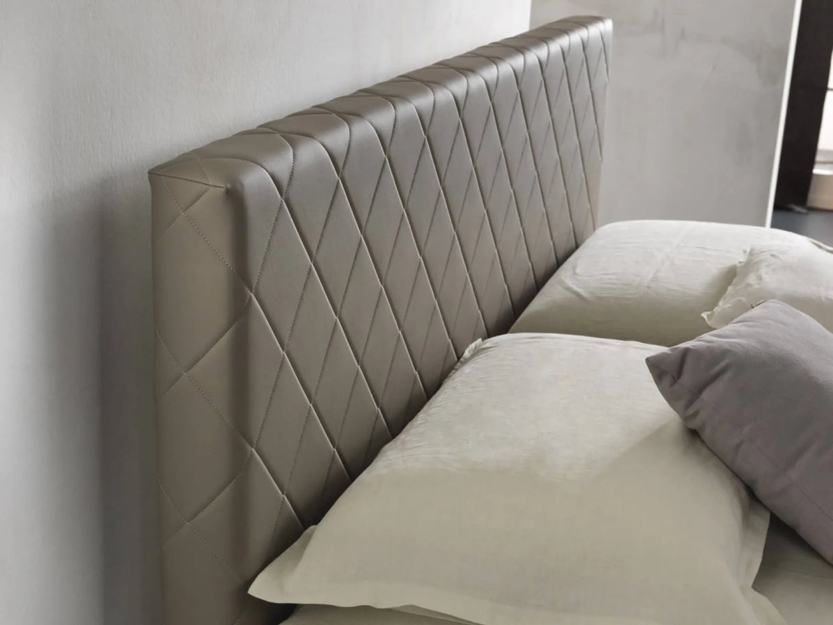 Letto matrimoniale Rio con contenitore, rivestimento in ecopelle e testata imbottita trapuntata a rombi. Design moderno, elegante e salvaspazio.