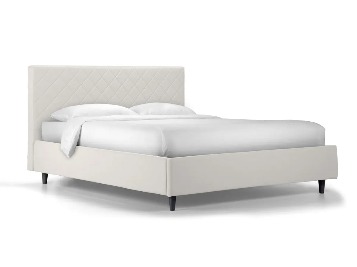 Letto singolo Rio con contenitore in ecopelle, testata trapuntata a rombi e piedini alti. Ideale per spazi moderni e camere eleganti.
