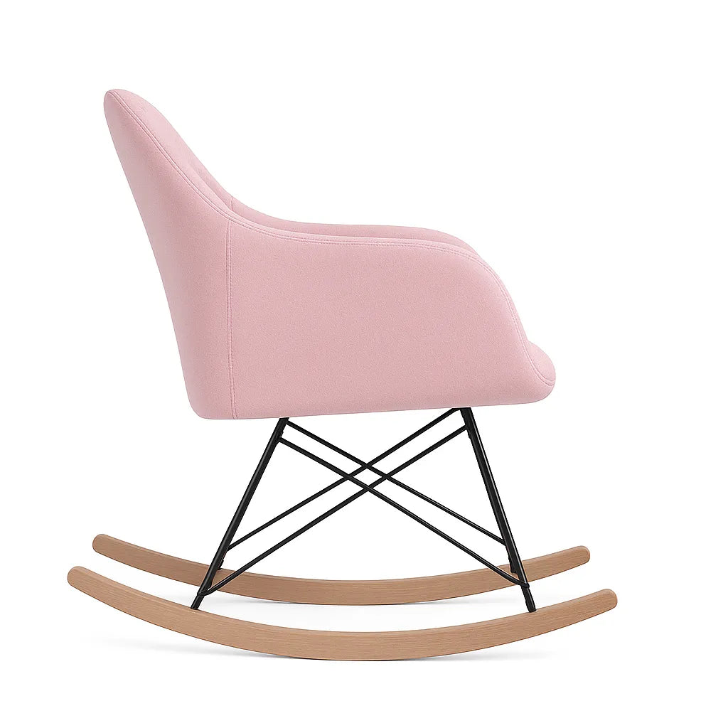 Poltrona a dondolo rosa in tessuto con base in legno naturale e schienale trapuntato stile scandinavo.