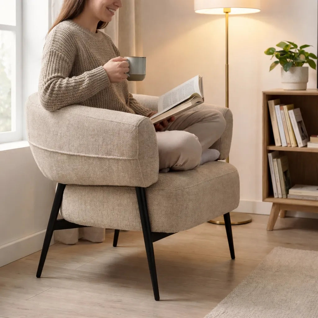 Poltrona Odeon in tessuto beige con schienale curvo e gambe in metallo nero design moderno elegante