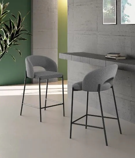 Sgabello Greta in tessuto grigio con schienale imbottito e gambe in metallo nero, ideale per penisola e cucina moderna