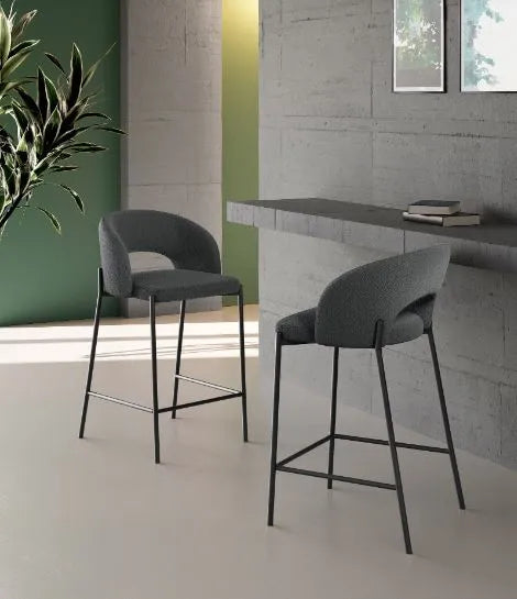 Sgabello Greta in tessuto grigio con schienale imbottito e gambe in metallo nero, ideale per penisola e cucina moderna
