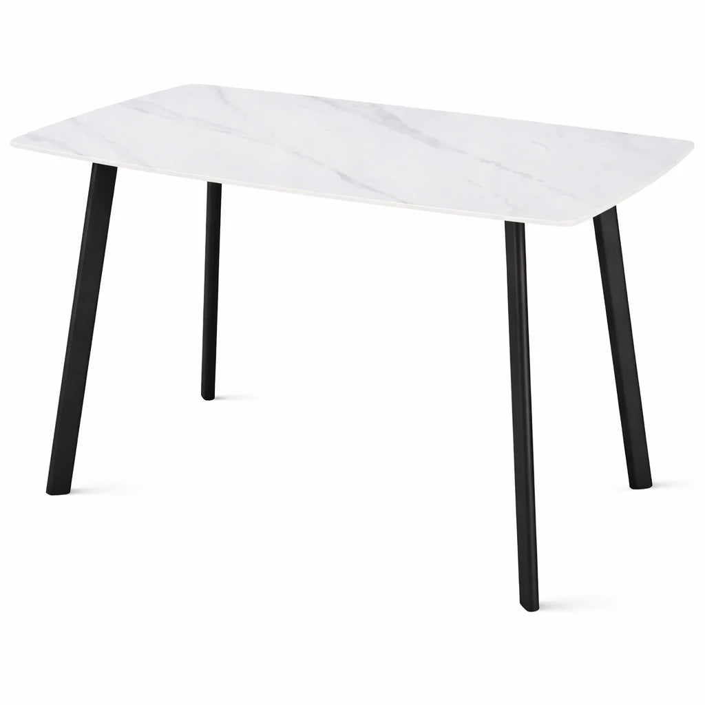 Tavolo Quincy rettangolare con piano in ceramica effetto marmo e gambe nere in metallo, ambientato in sala da pranzo moderna con sedie coordinate