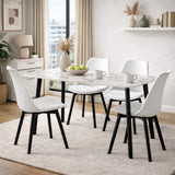Tavolo Quincy rettangolare con piano in ceramica effetto marmo e gambe nere in metallo, ambientato in sala da pranzo moderna con sedie coordinate
