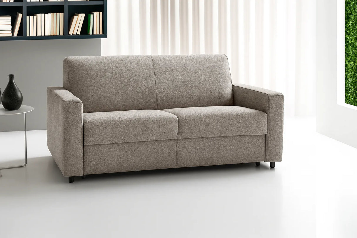 Divano letto in tessuto disponibile in vari colori con materasso alto, rete elettrosaldata, apertura a ribalta, struttura in metallo resistente e vano portacuscini integrato.