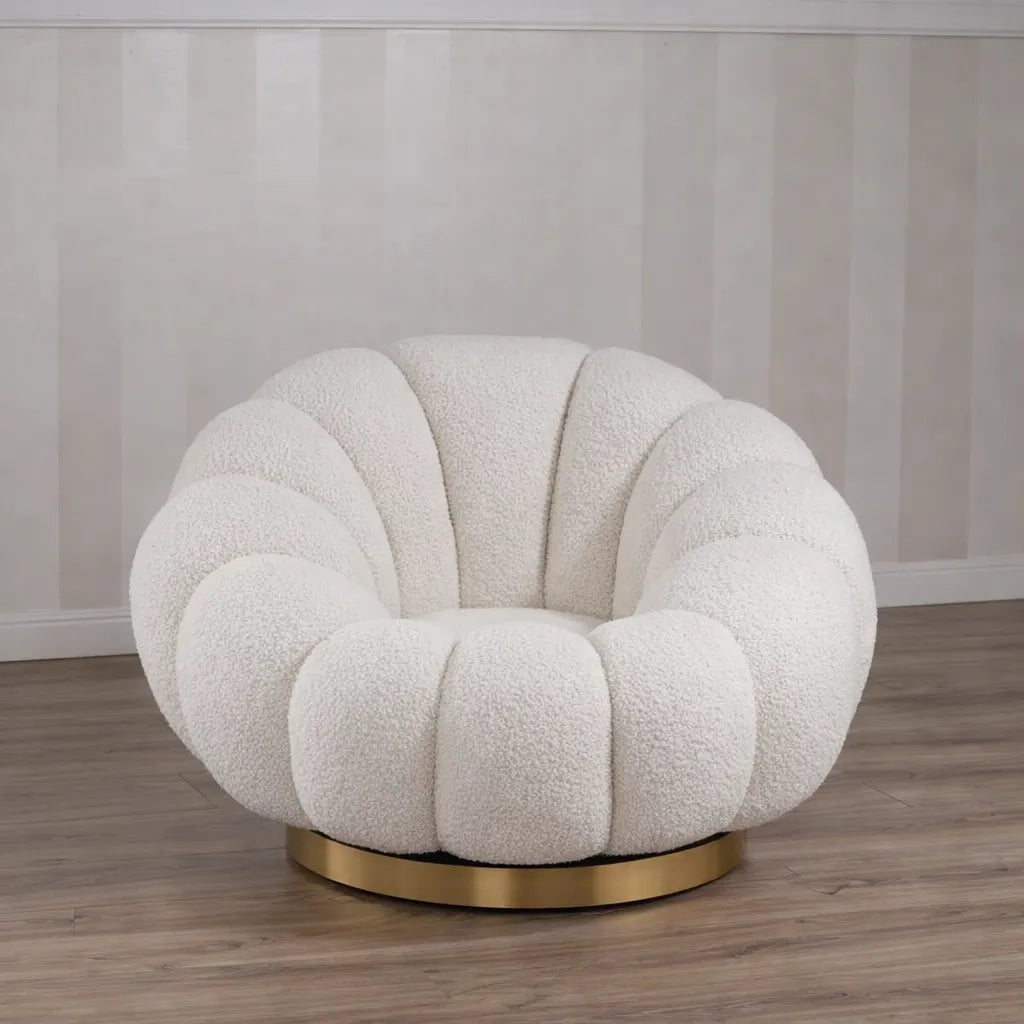 Poltrona Elodia in tessuto bouclé color panna con seduta avvolgente e base circolare in metallo color oro