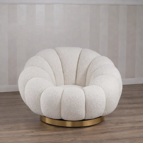 Poltrona Elodia in tessuto bouclé color panna con seduta avvolgente e base circolare in metallo color oro