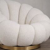 Poltrona Elodia in tessuto bouclé color panna con seduta avvolgente e base circolare in metallo color oro