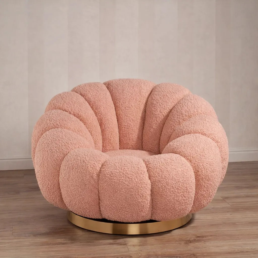 Poltrona Elodia in tessuto bouclé color rosa con seduta avvolgente e base circolare in metallo color oro