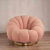 Poltrona Elodia in tessuto bouclé color rosa con seduta avvolgente e base circolare in metallo color oro