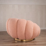 Poltrona Elodia in tessuto bouclé color rosa con seduta avvolgente e base circolare in metallo color oro
