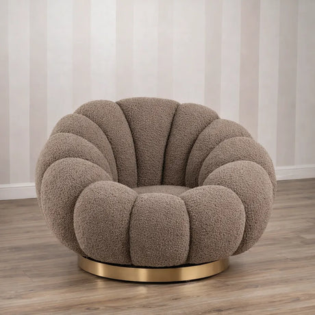 Poltrona Elodia in tessuto bouclé color tortora con seduta avvolgente e base circolare in metallo color oro