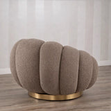 Poltrona Elodia in tessuto bouclé color tortora con seduta avvolgente e base circolare in metallo color oro