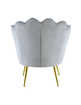 Poltrona in velluto con schienale a conchiglia e gambe dorate, ideale per soggiorno, camera da letto o ambienti eleganti.