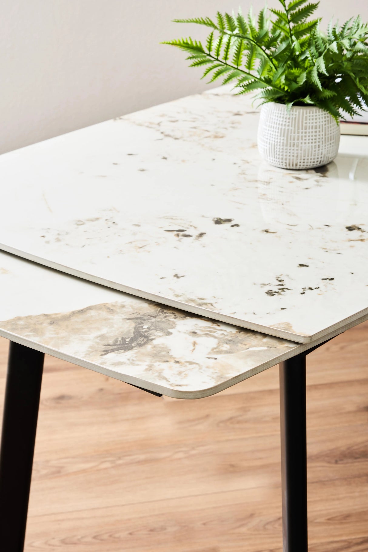 Tavolo allungabile Quincy con piano in ceramica effetto marmo e gambe in metallo nero