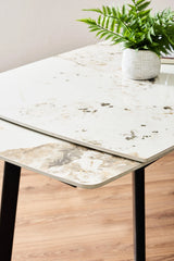 Tavolo allungabile Quincy con piano in ceramica effetto marmo e gambe in metallo nero