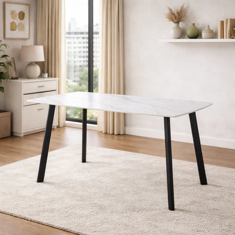 Tavolo Quincy rettangolare con piano in ceramica effetto marmo e gambe nere in metallo, ambientato in sala da pranzo moderna con sedie coordinate
