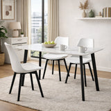 Tavolo Quincy rettangolare con piano in ceramica effetto marmo e gambe nere in metallo, ambientato in sala da pranzo moderna con sedie coordinate

