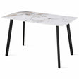 Tavolo Quincy rettangolare con piano in ceramica effetto marmo e gambe nere in metallo, ambientato in sala da pranzo moderna con sedie coordinate

